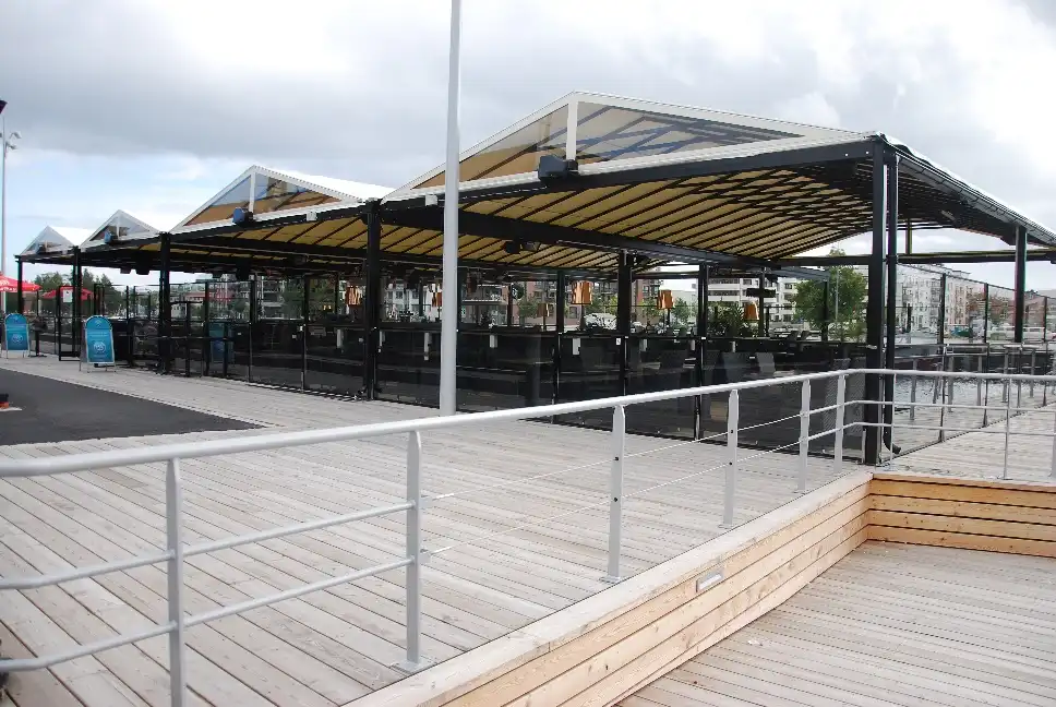 uteservering med svarta stålpelare och vitt textiltak.